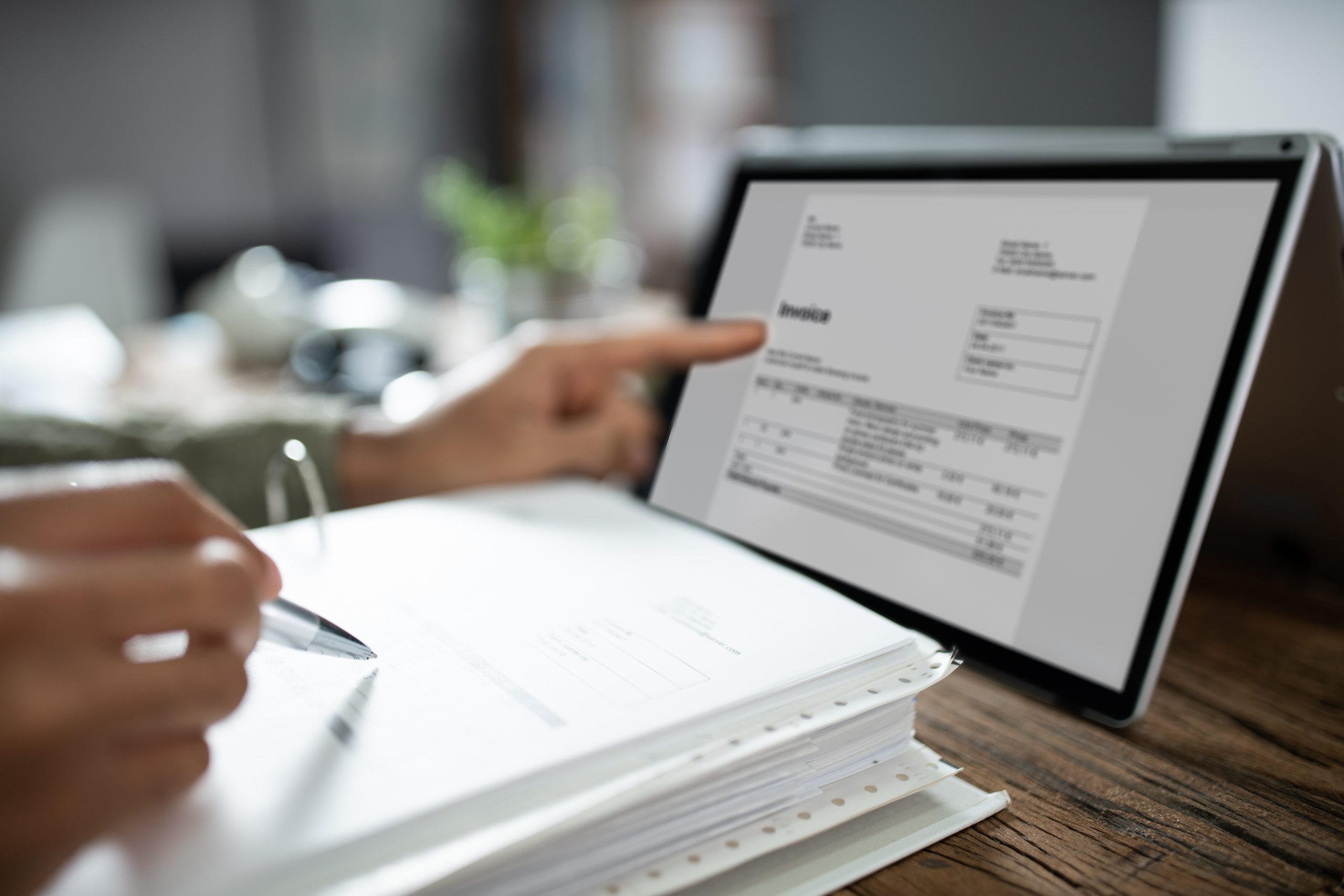 a woman typing an invoice into a telecom billing management system in the office