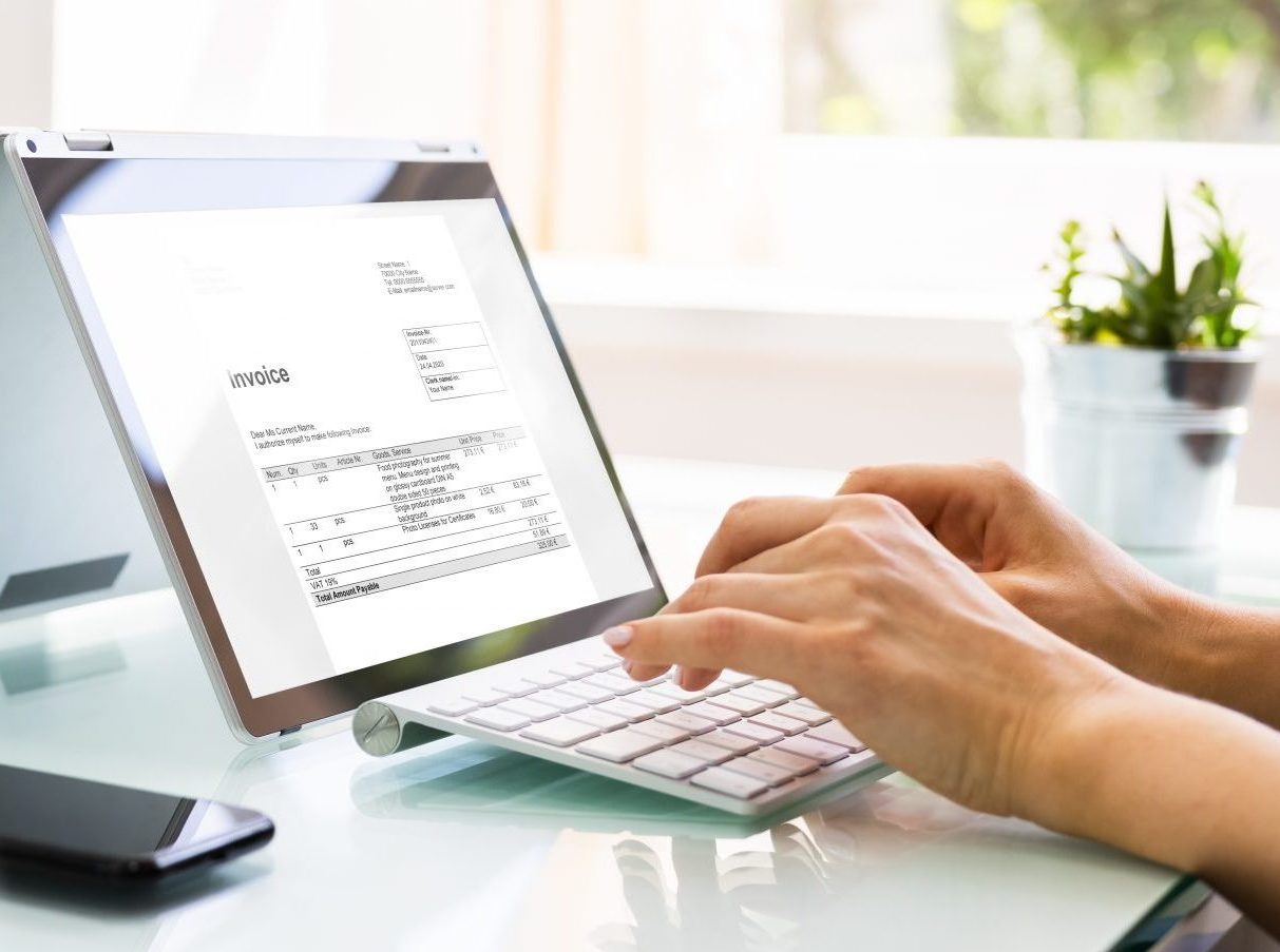 a woman typing an invoice into a telecom billing management system