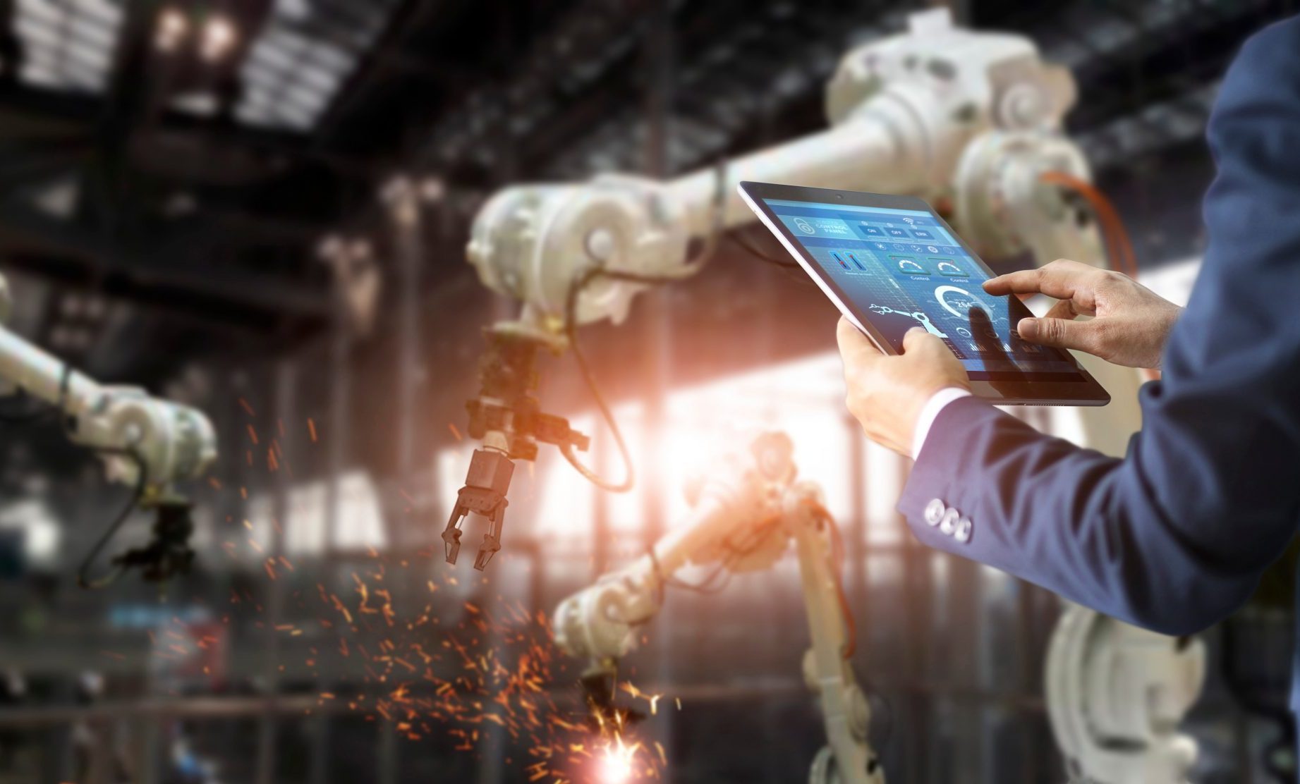 man using a tablet in a manufacturing facility to manage telecom expenses